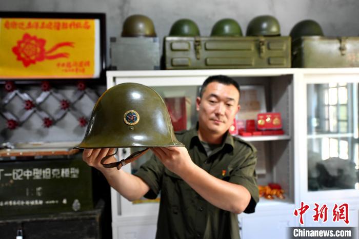 图为收藏爱好者王栋介绍收藏的军用头盔。　吕明 摄